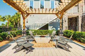 A patio with tables and chairs under a wooden pergola